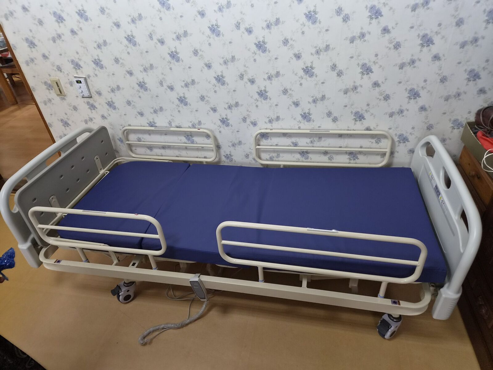 안산 재가복지와 함께 안내하는 복지용구 참고사진 - 꽃무늬 벽지 방에 설치된 안전난간 전동침대